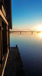 View of bridge over river at sunset