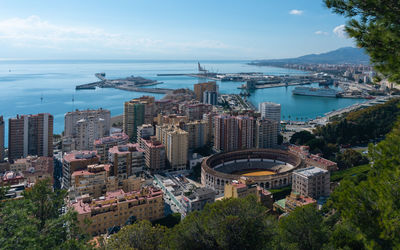 High angle view of cityscape by sea against sky