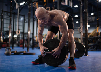 Bald senior athlete preparing for weightlifting training