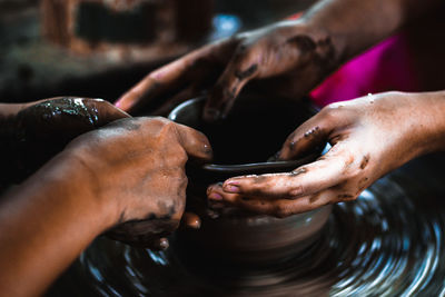 Cropped hands making clay pot