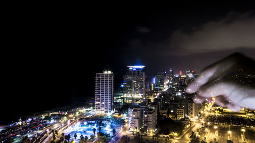 Illuminated city against sky at night