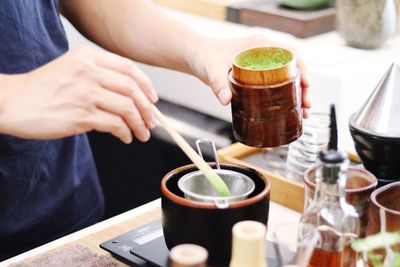 Midsection of people holding drink on table