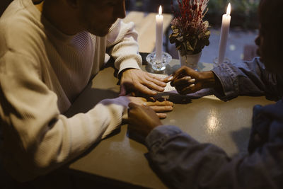 High angle view of couple playing while sitting at table during date in restaurant