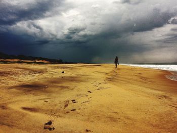 Scenic view of beach against cloudy sky