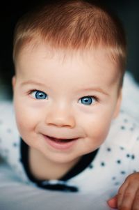 Close-up portrait of cute happy baby boy with blue eyes
