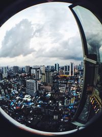 View of cityscape against cloudy sky