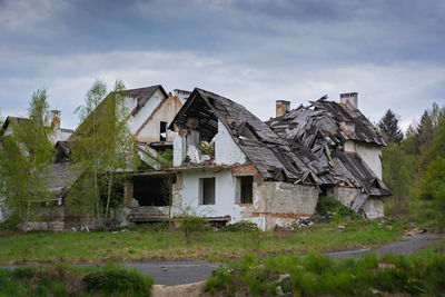 Abandoned house on field against sky