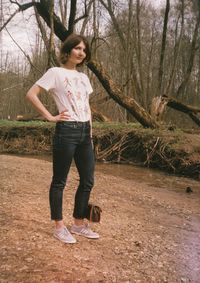 Full length of woman standing on bare tree