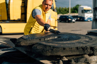 Man repairing truck outside workshop