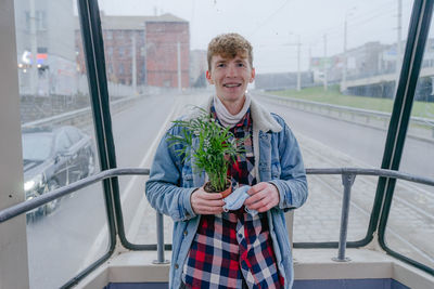 Smiles in public transport, does not hesitate to show braces in a public place, with curly hair