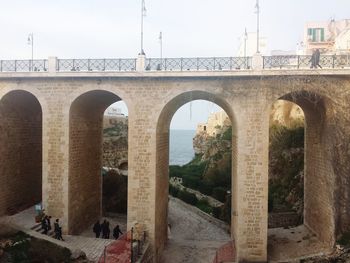 Arch bridge against sky in city