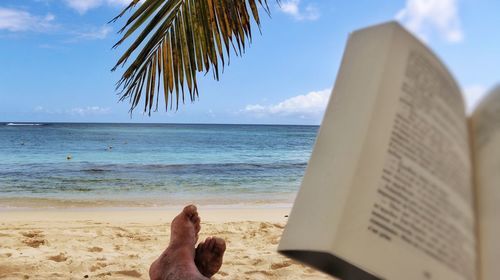 Low section of man relaxing on beach