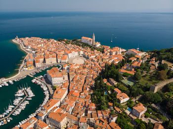 High angle view of townscape by sea against sky