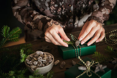 Woman making beautiful christmas gift at table