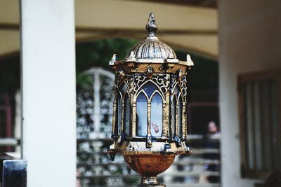 Close-up of illuminated lamp against building