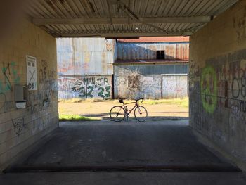 Bicycle parked on road against old factory