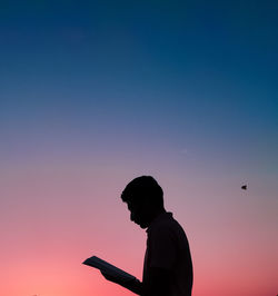 Silhouette man standing against sky during sunset