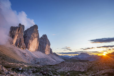 Panoramic view of rocky mountains against sky during sunset