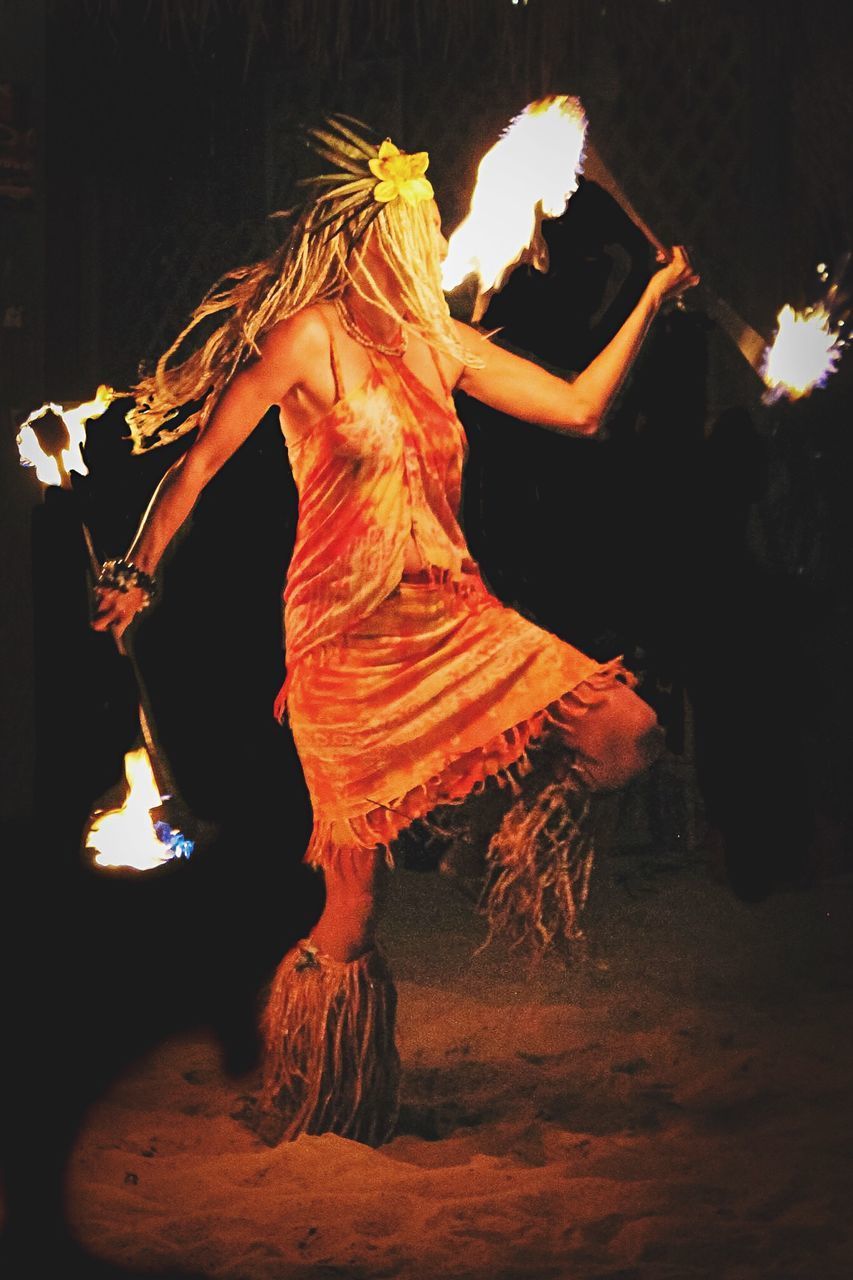 MIDSECTION OF WOMAN DANCING AT NIGHT DURING FESTIVAL