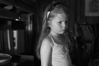 Unhappy girl looking away while standing at home