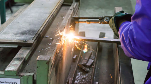 Midsection of man welding at factory