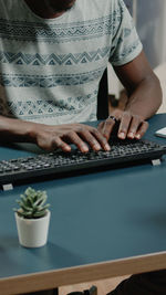 Midsection of woman using laptop on table