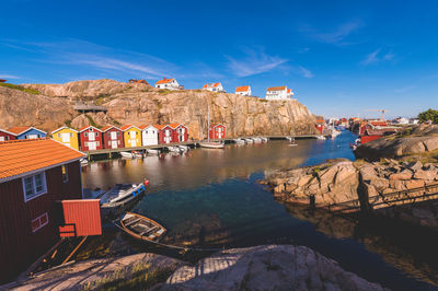 Buildings by rocks against blue sky