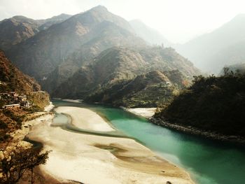 Beas river flowing amidst mountains in foggy weather