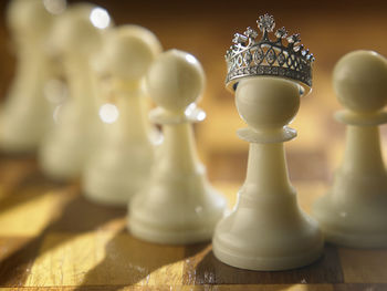 Close-up of crown on pawn at chess board