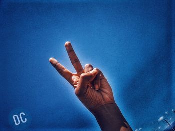 Low angle view of person against blue sky