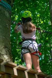 Low angle view of girl standing by tree