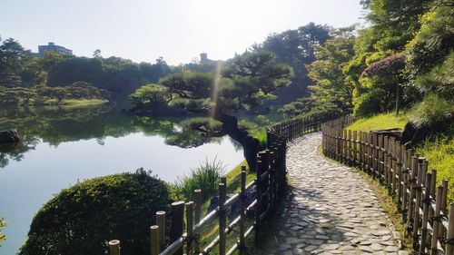 Footpath by river against sky