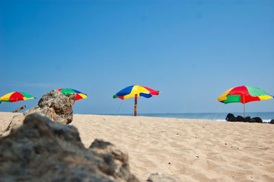 Umbrella on beach against clear sky