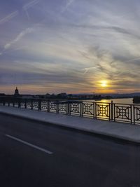 Bridge over river against sky during sunset