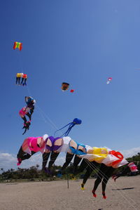 Low angle view of balloons flying against blue sky