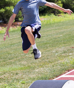 Low section of man jumping on grass