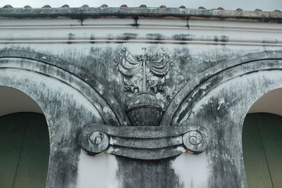 Close-up of old sculpture against building