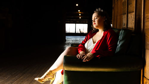 Portrait of young woman sitting on sofa at home