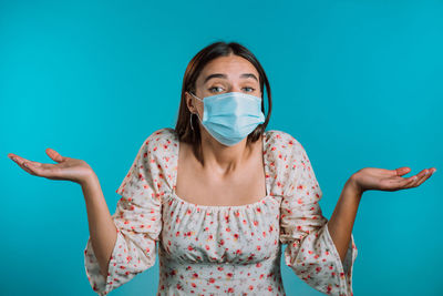 Portrait of young woman against blue background