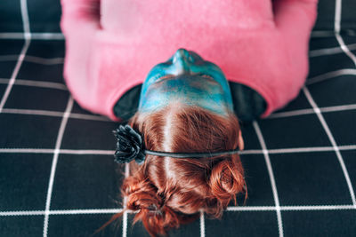 Close-up of woman with blue face paint lying on sofa