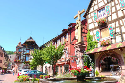 Low angle view of buildings on street against blue sky