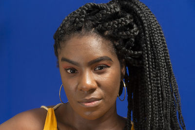 Young woman wearing colorful long clothes over blue background. natural expression.