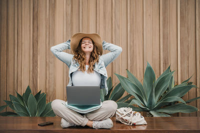 Young woman using laptop while sitting on table