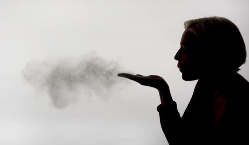 Portrait of man smoking against white background