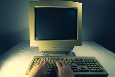 Close-up of hand using laptop on table