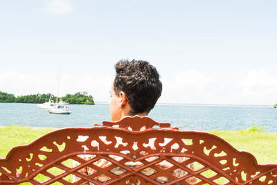 Rear view of man in sea against sky