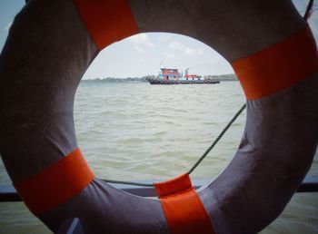 Close-up of boat sailing in sea against sky