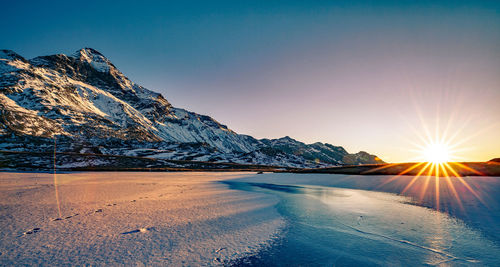 Scenic view of snowcapped mountains against sky during sunset