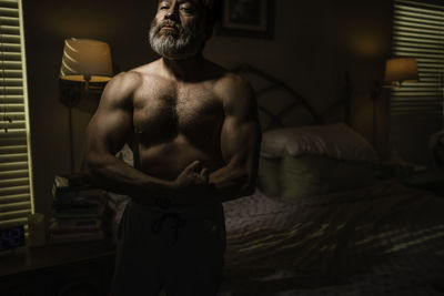 Rear view of shirtless man standing at home