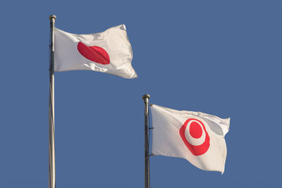 Low angle view of flag against blue sky